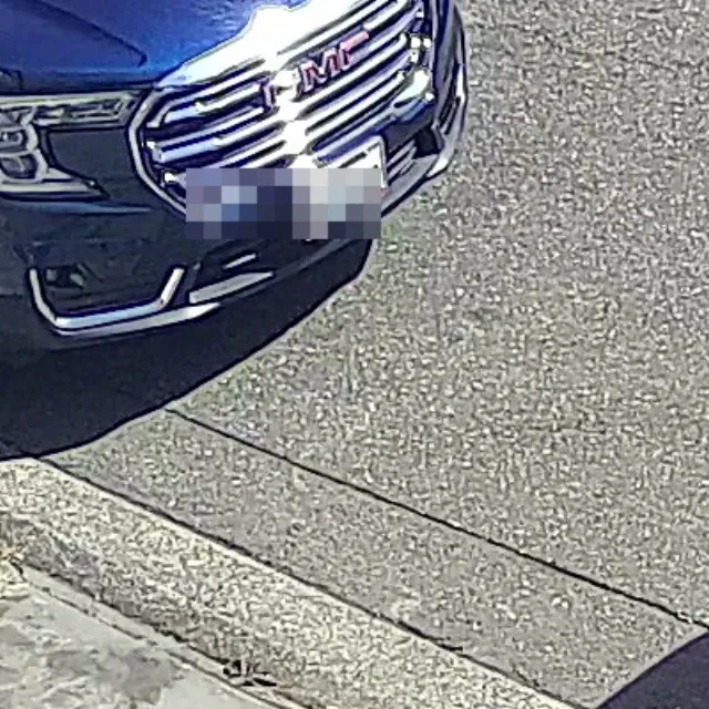 FDC codec reconstruction at t=2m, outdoor parking scene with parked GMC (license plate pixelated)