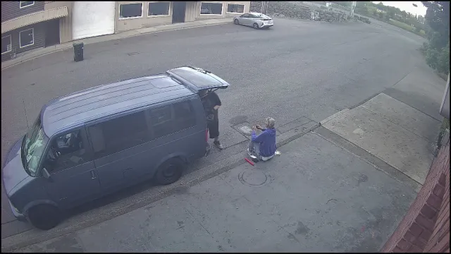 Vigil S1 Info alert — two individuals at a blue van with rear door open in off-hours parking lot, May 2026