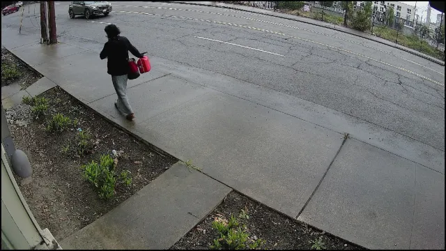 Vigil S3 Medium alert — person walking on sidewalk carrying two red gas canisters, May 2026